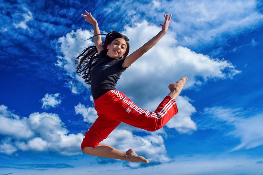 confident girl jumping in air in summer