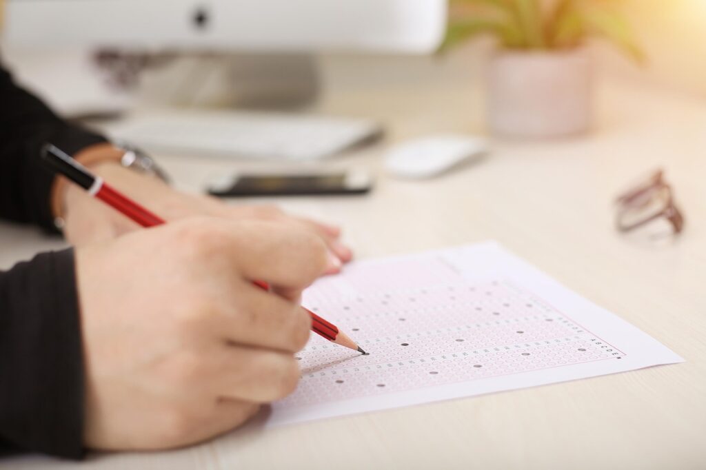 child sitting GCSE exam at desk with pencil in hand