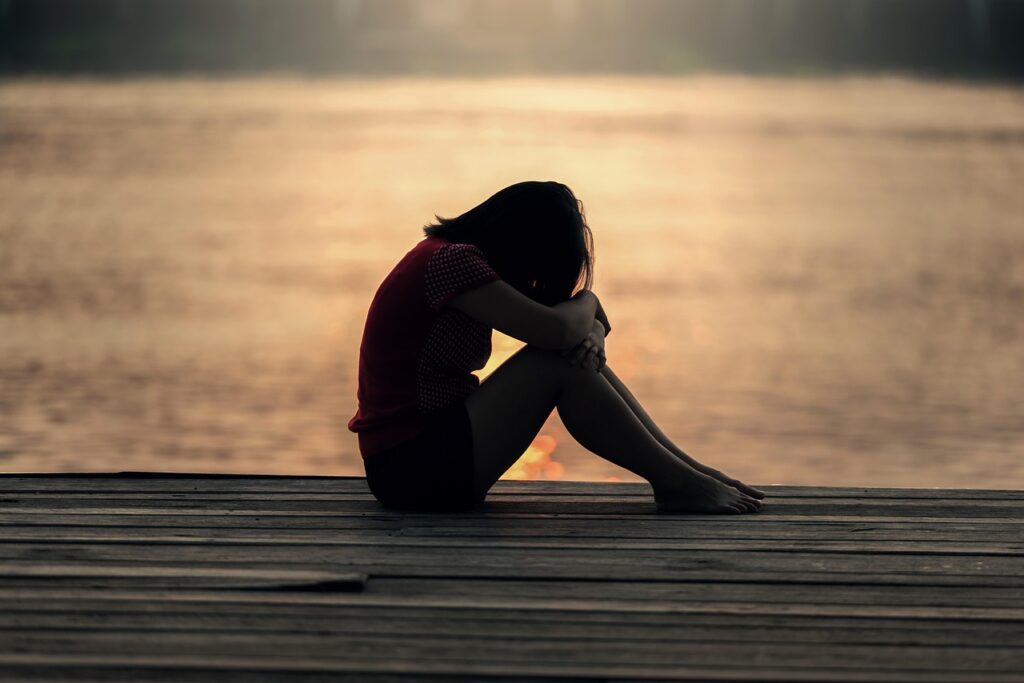 girl sitting down looking sad due to academic burnout