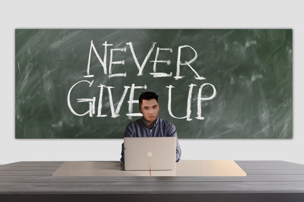 student sat in front of school board that says 'never give up'